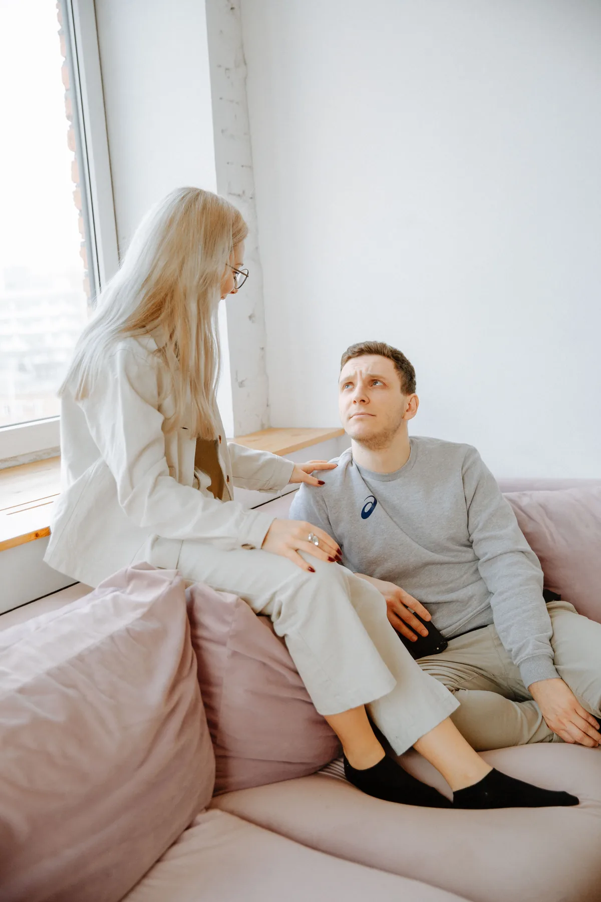 Pareja conversando de noche en el sofá, gesto de escucha y cercanía